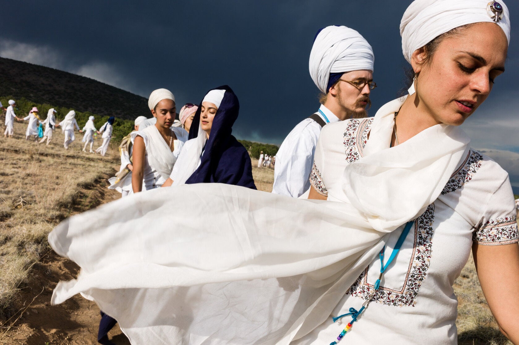 &laquo;Il existe des m&eacute;thodes&nbsp;traditionnelles en Inde o&ugrave; vous vivez dans un ashram, faites v&oelig;u de c&eacute;libat et vivez une vie de service aust&egrave;re, mais ce n'est qu'une fa&ccedil;on de pratiquer le yoga. Pour beaucoup en Occident, il est plus r&eacute;aliste et pratique d&rsquo;avoir un travail, une famille et d'avoir des outils pour naviguer dans la vie avec gr&acirc;ce et aisance. Cela ne veut pas dire sans difficult&eacute;s, mais le yoga am&eacute;liore nos capacit&eacute;s et nous donne des moyens pour traverser la vie avec int&eacute;grit&eacute;. Sur cette image, les yogis du Nouveau-Mexique se prom&egrave;nent en aveugle dans le paysage aride, apr&egrave;s deux jours et demi de yoga tantrique blanc. Les yeux ferm&eacute;s, le groupe est dirig&eacute; par un leader qui dit &ldquo;Wahe Guru&rdquo;; ceux qui suivent r&eacute;pondent avec la m&ecirc;me formule &ndash;expression de la crainte extatique du divin,&nbsp;partageant &agrave; voix haute l'exp&eacute;rience du passage des t&eacute;n&egrave;bres &agrave; la lumi&egrave;re, de l'ignorance &agrave; vraie compr&eacute;hension.&raquo; 